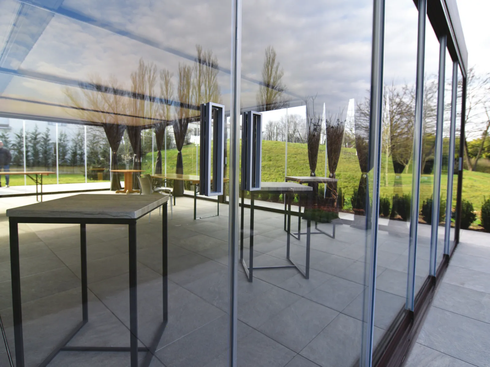 Ante di Sliding Floor accostate, con le maniglie e il giardino sullo sfondo