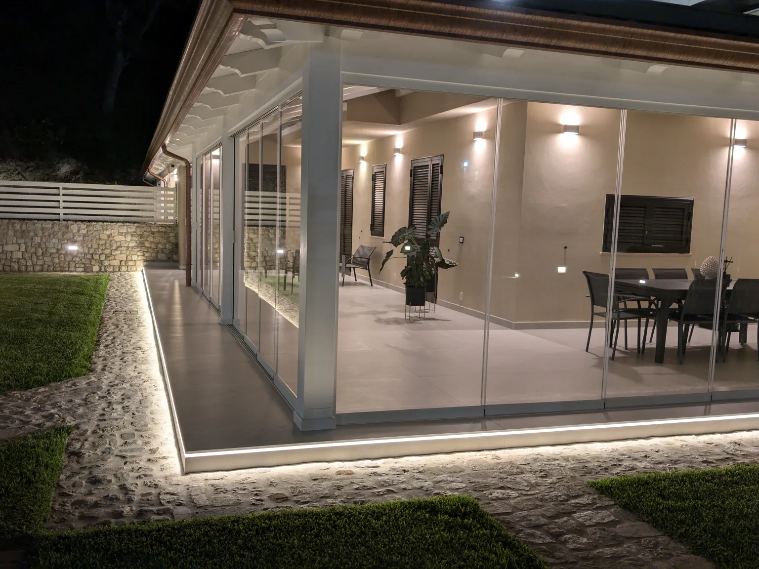 Sliding Floor illuminata di sera, sala da pranzo vista dal giardino
